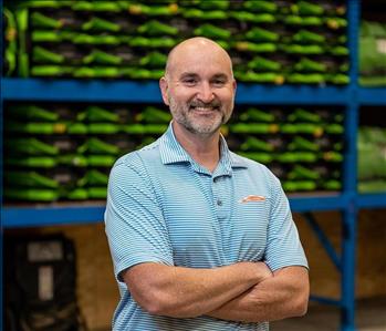 Danny is a white male who is bald and wearing a blue and white stripped servpro polo