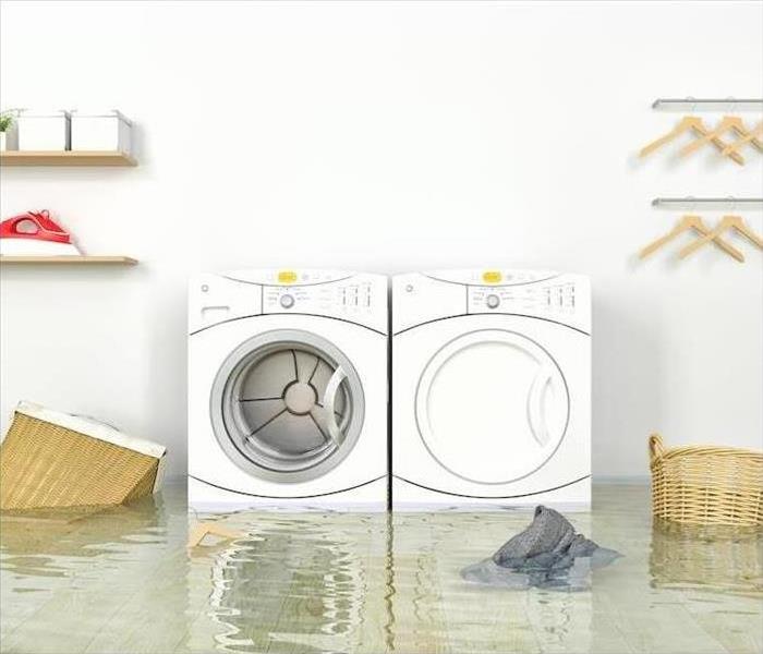 White washer and dryer in a laundry room that are submerged in water